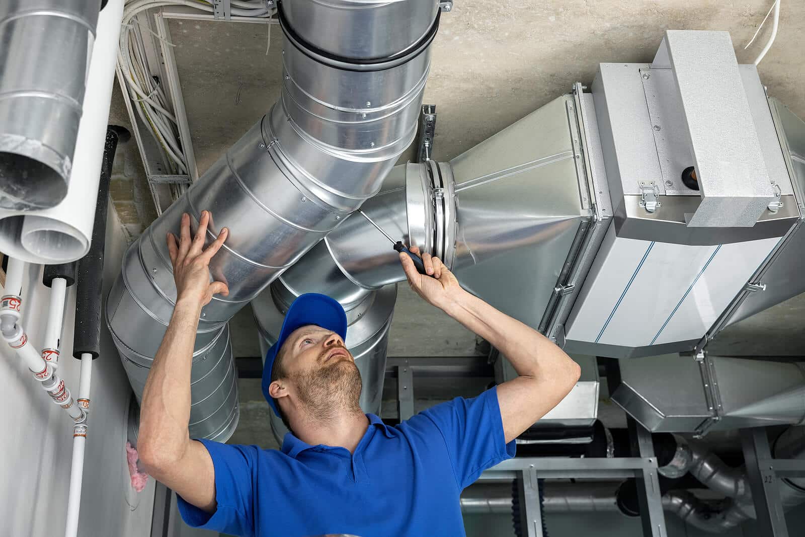 HVAC technician inspecting and repairing air ducts in Downey