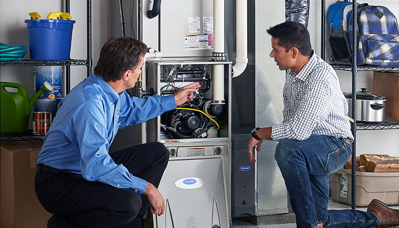 Technician evaluating a furnace for repair or replacement in Downey