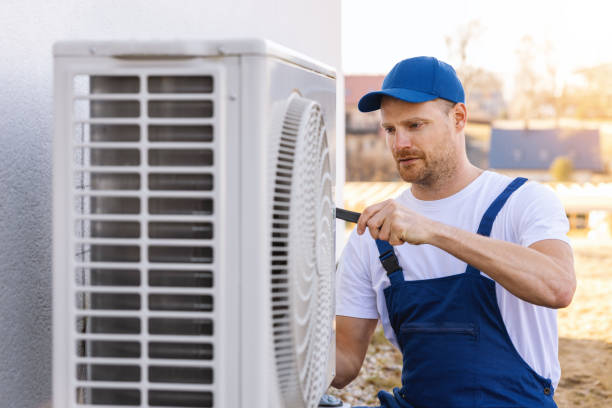 HVAC technician servicing an outdoor air conditioner in Downey